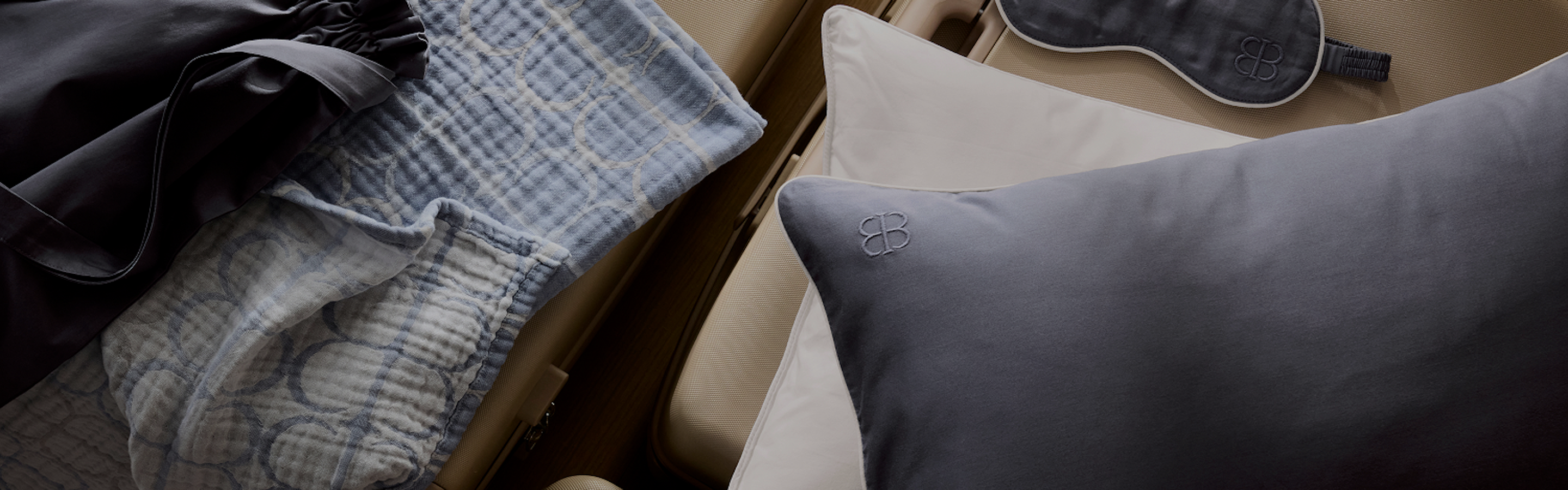 Three piece travel kit arranged on organic bedding